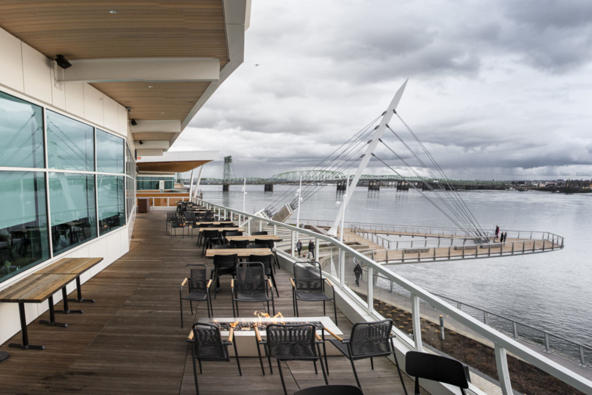 Restaurant exterior, tables lined up, river in the back